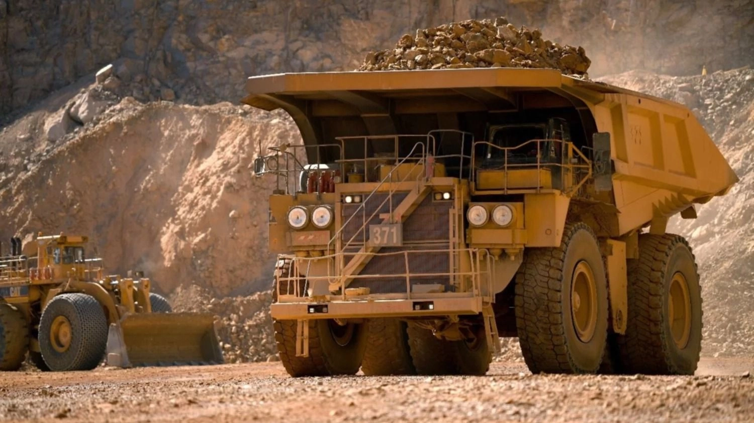  Camión de gran porte cargado con rocas de mineral dentro de una operación minera a cielo abierto.