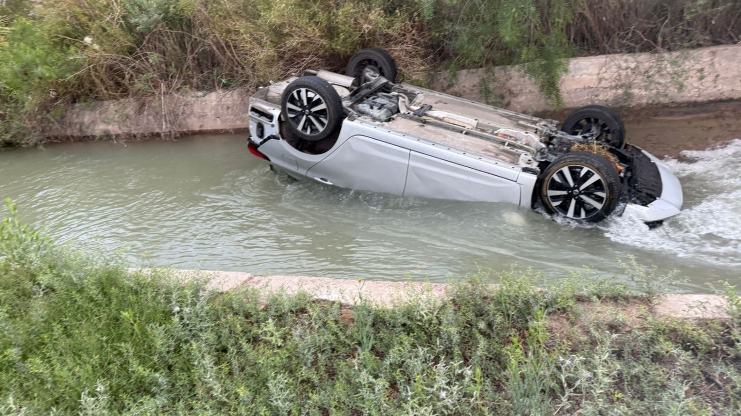 Un conductor volcó su auto y terminó en un canal de riego