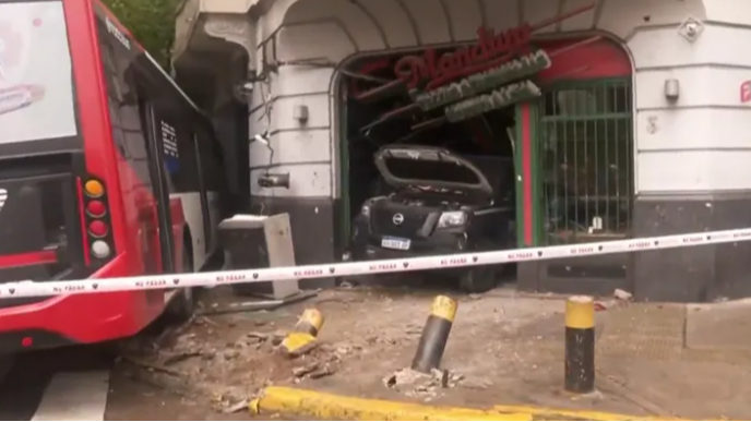 Un patrullero chocó con un colectivo y terminó adentro de una pizzería