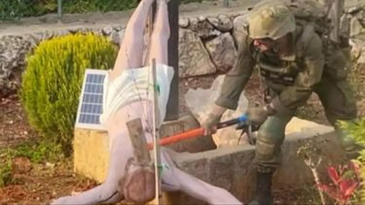 Un soldado israelí destruye a martillazos una figura de Cristo en el sur del Líbano