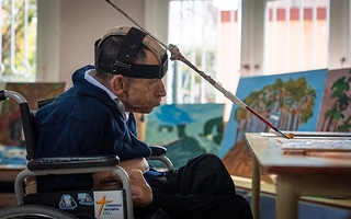 Tiene parálisis cerebral, pinta con la cabeza y ya vendió varias obras